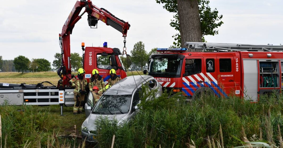 Auto op z'n kant in het water bij Kanaalweg in Oostburg