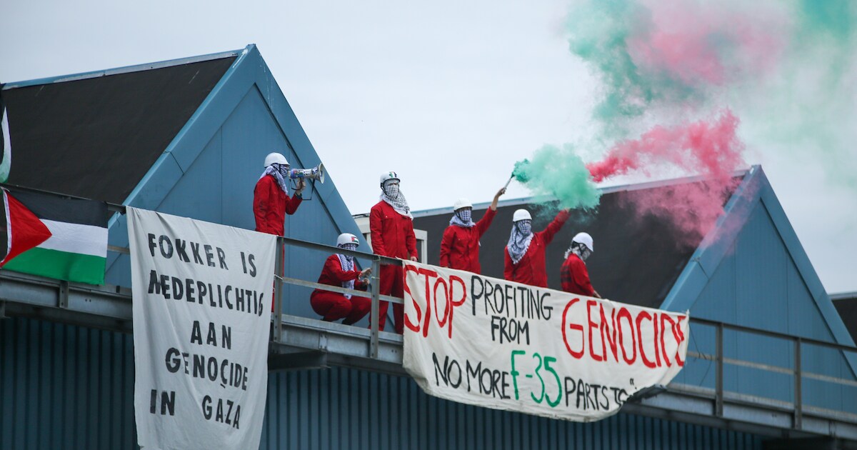 Demonstranten klimmen op dak Fokker in Papendrecht, zwaaien met fakkels en Palestijnse vlaggen