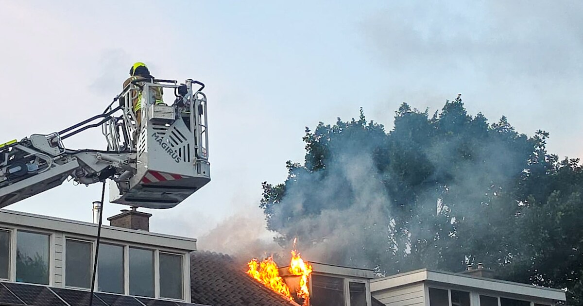 Vlammen slaan uit dakkapel bij woningbrand in Zwijndrecht, brand onder controle