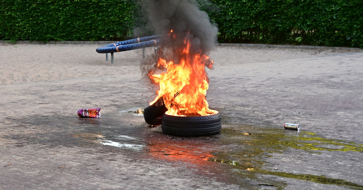Autobanden in brand gestoken op speelplaats in Breda, buurtbewoners proberen te blussen met emmers w
