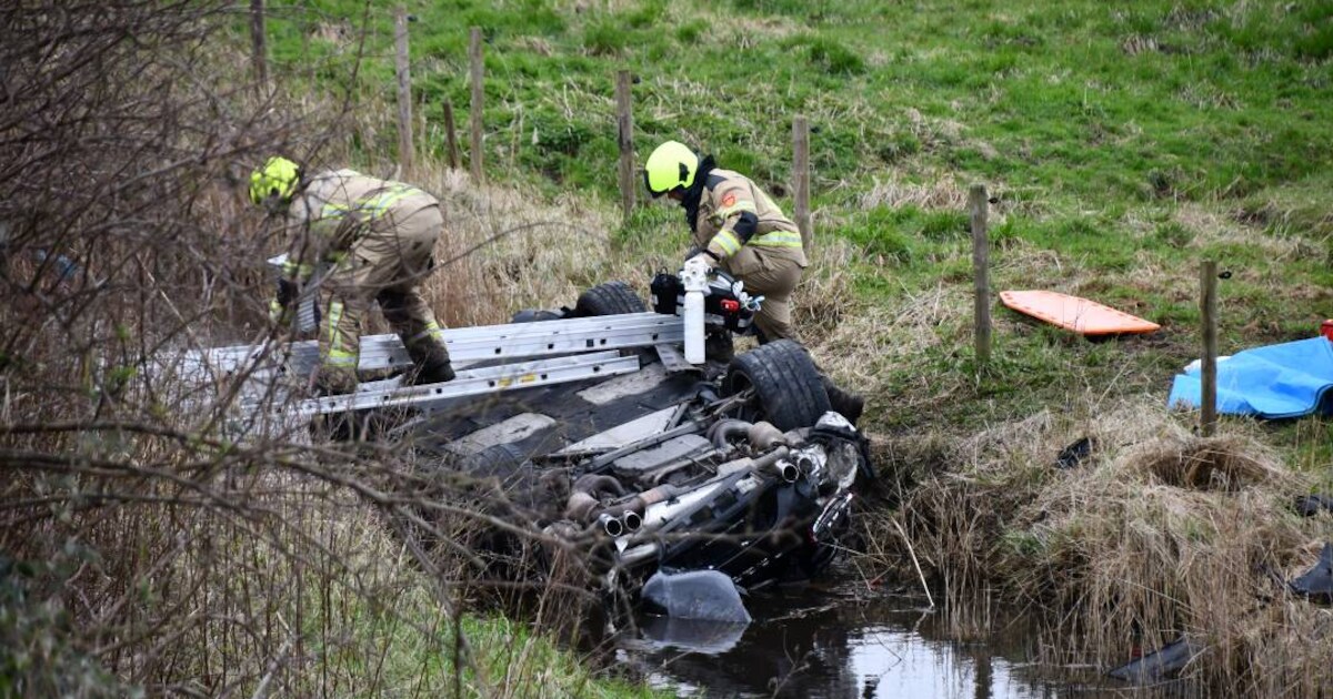 Auto te water in Hoedekenskerke: inzittenden klimmen uit voertuig