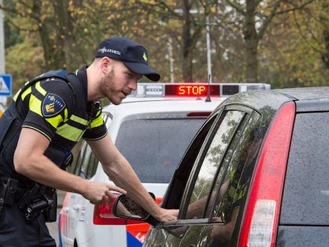 Een agent houdt een automobilist aan. Foto ter illustratie.