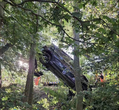 Flinke crash eindigt op wonderbaarlijke plek: auto bungelt metershoog in bomen